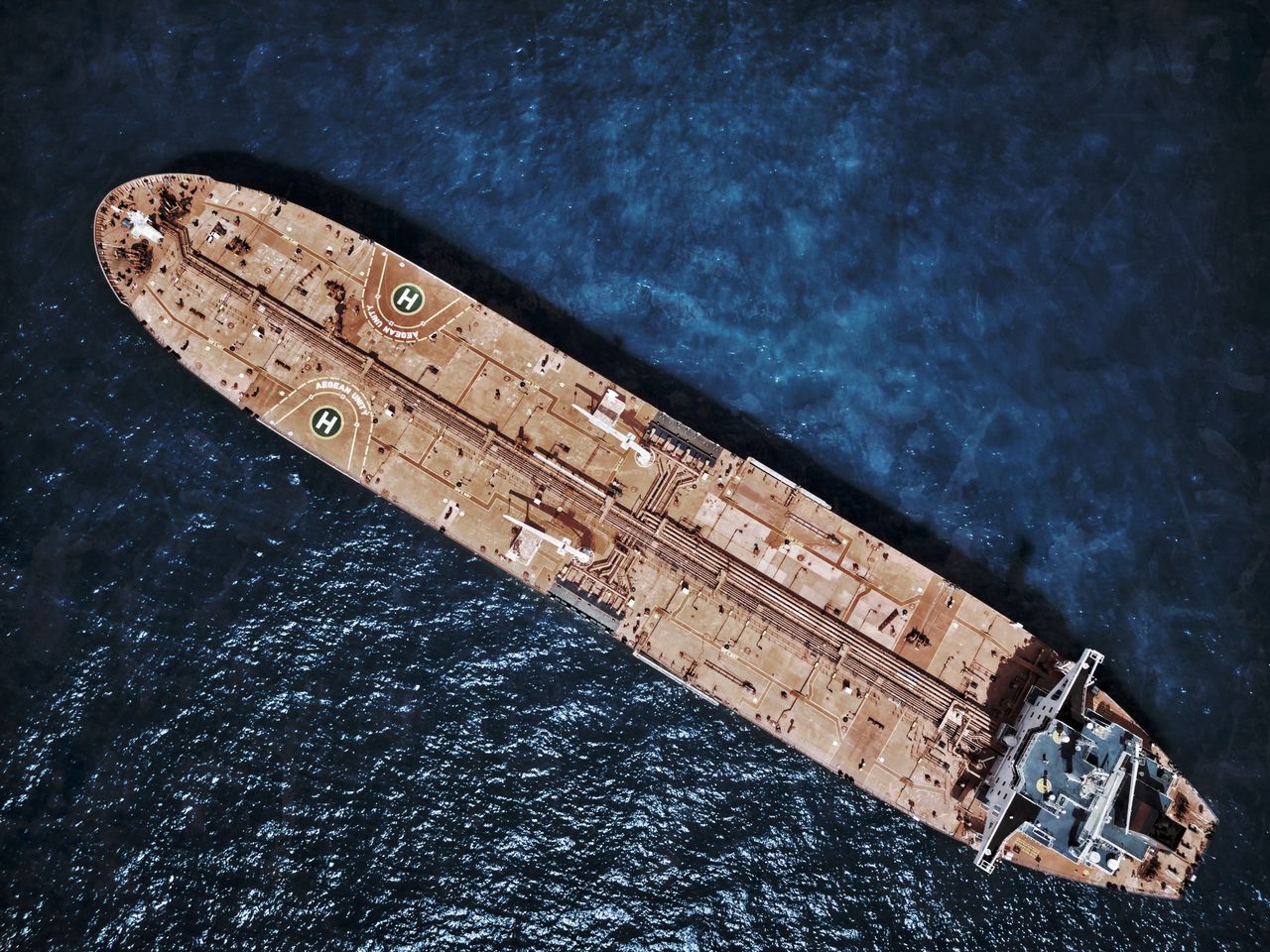 Home Drone shot of large tanker ship with helipads in ocean waters.